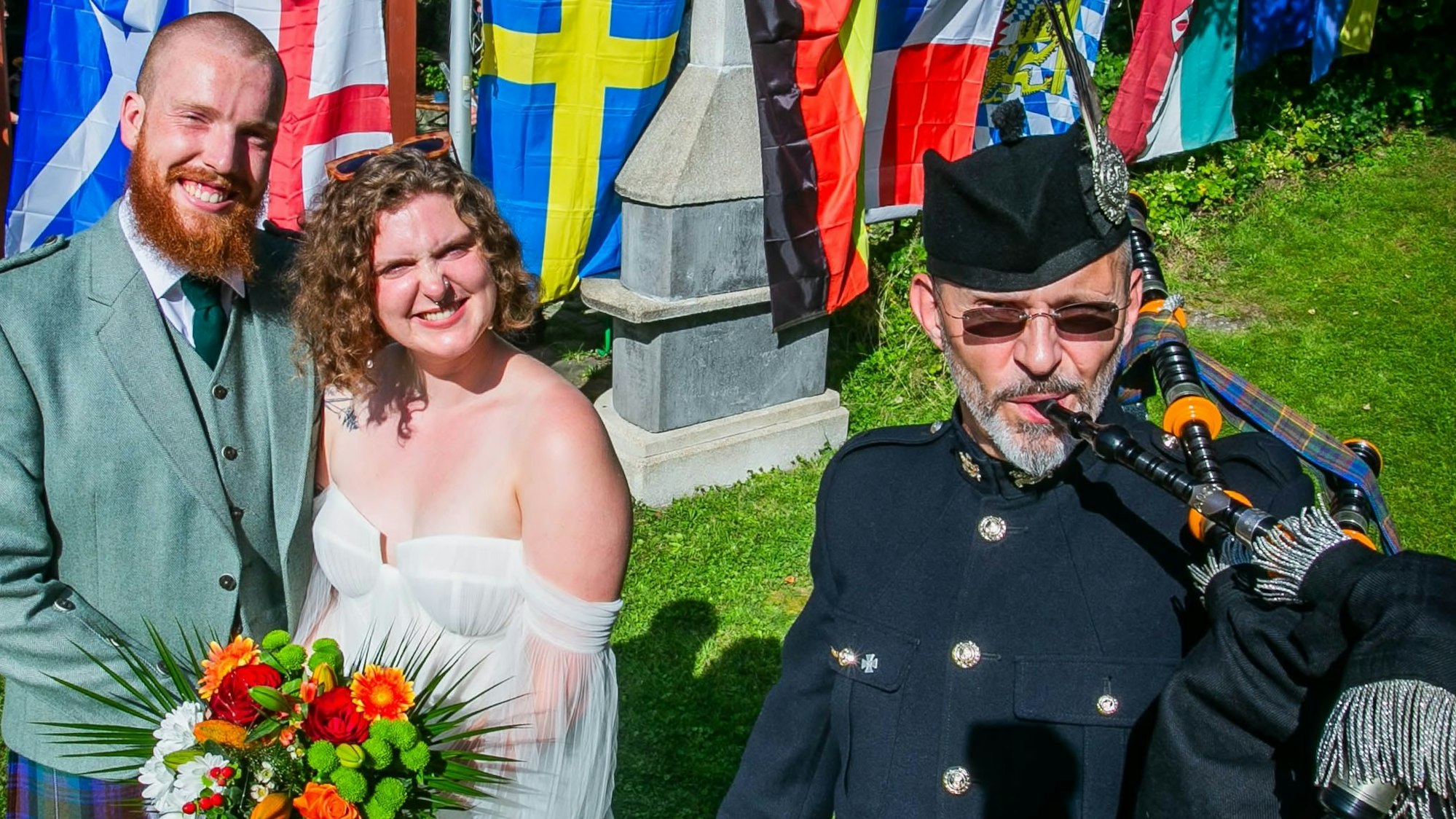 Mit Musik von Dudelsackspieler Michael Hoffmann von der Gruppe „Call of Pipes“ aus Waldbröl feiert das schottische Paar Nils und Anna Fritsch am Samstagnachmittag in Wiehl-Merkausen und im Kreise der weitverzweigten Familie noch einmal Hochzeit. Hier steht das Paar vor den Fahnen der beteiligten Nationen.