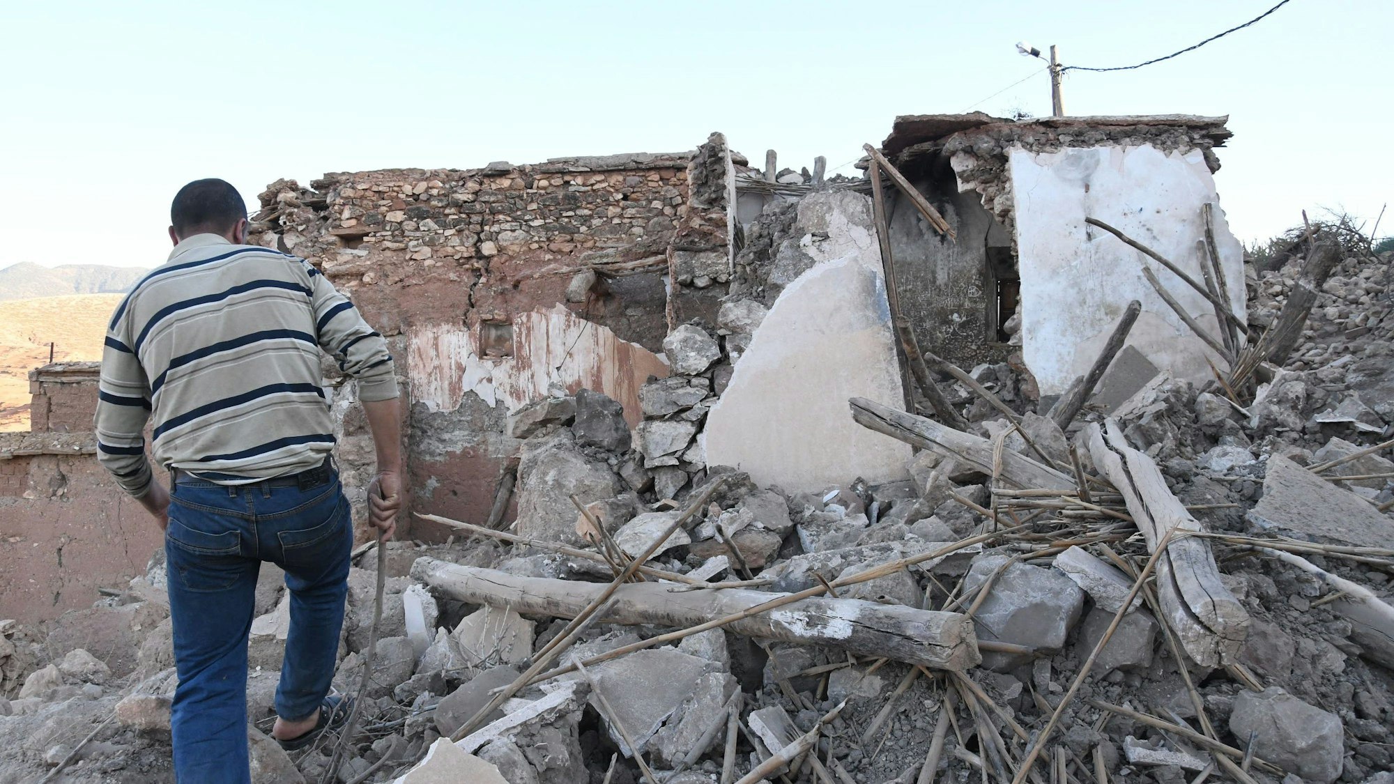 Ein Mann geht zwischen den Trümmern eines beschädigten Gebäudes in der Nähe von Marrakesch nach einem Erdbeben.