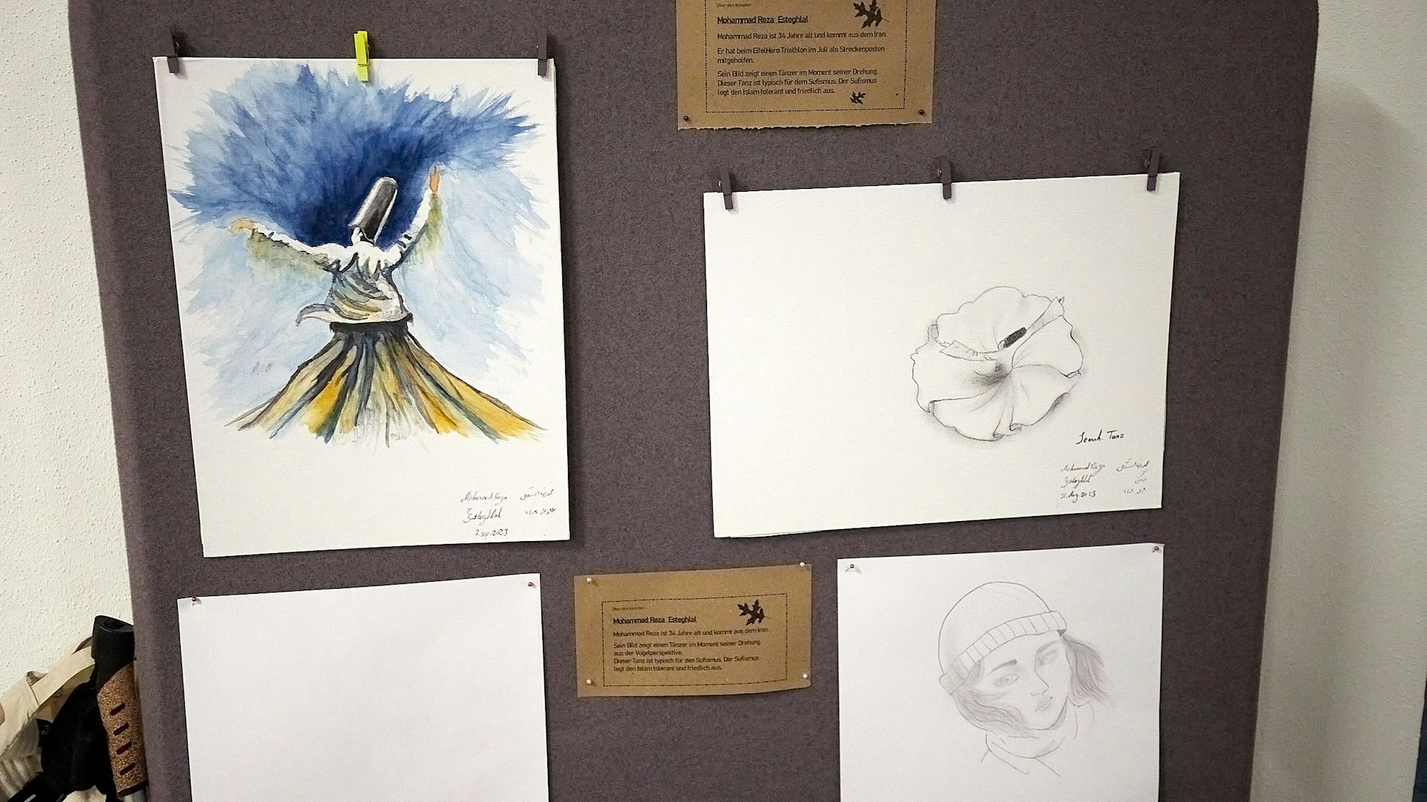 Verschiedene Bleistiftzeichnungen und ein Aquarell sind auf einer Stellwand angepinnt.