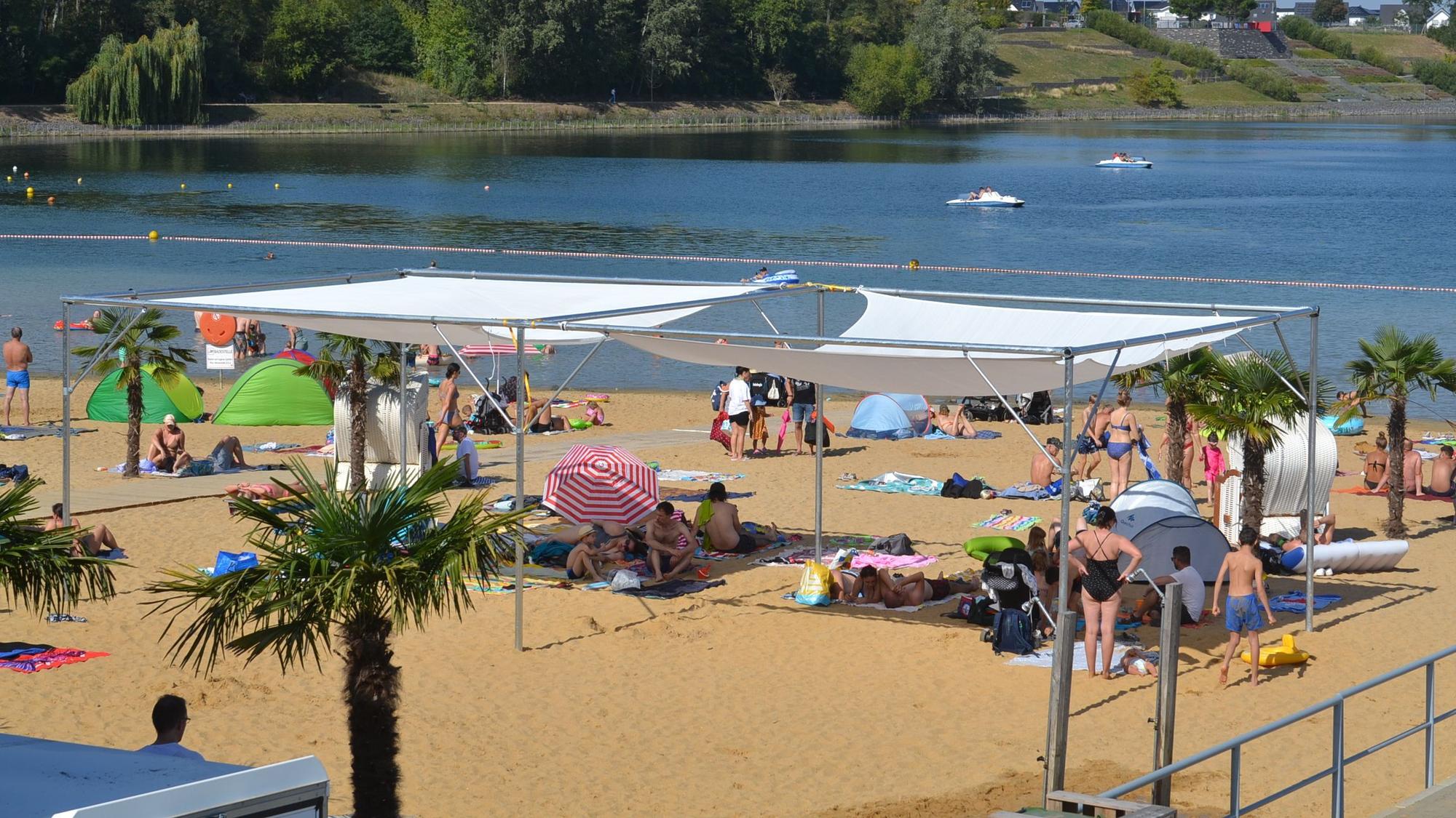 Badegäste am Sandstrand des Wassersportsees in Zülpich.