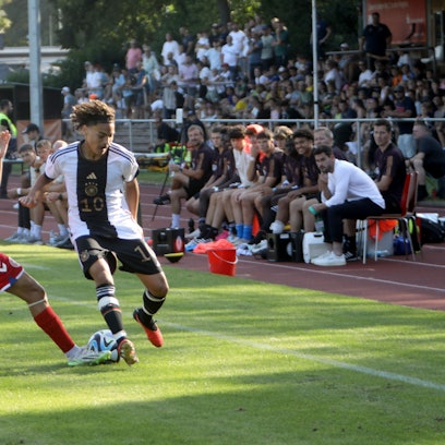Zwei Fußballspieler kämpfen um den Ball.