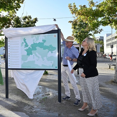 Vier Menschen enthüllen eine neue Tafel am „Platz der Partnerstädte“ in Bergisch Gladbach.