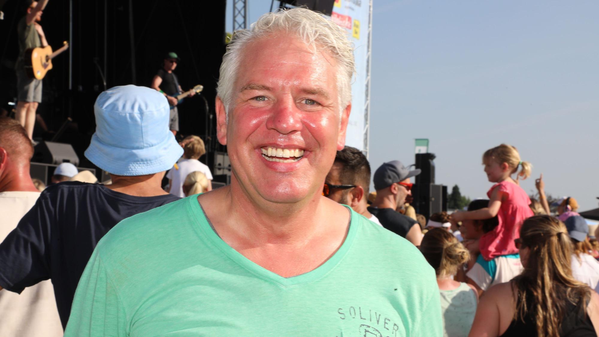 Odenthals Bürgermeister Robert Lennerts steht beim Rheinbrand-Festival vor der Bühne und strahlt.