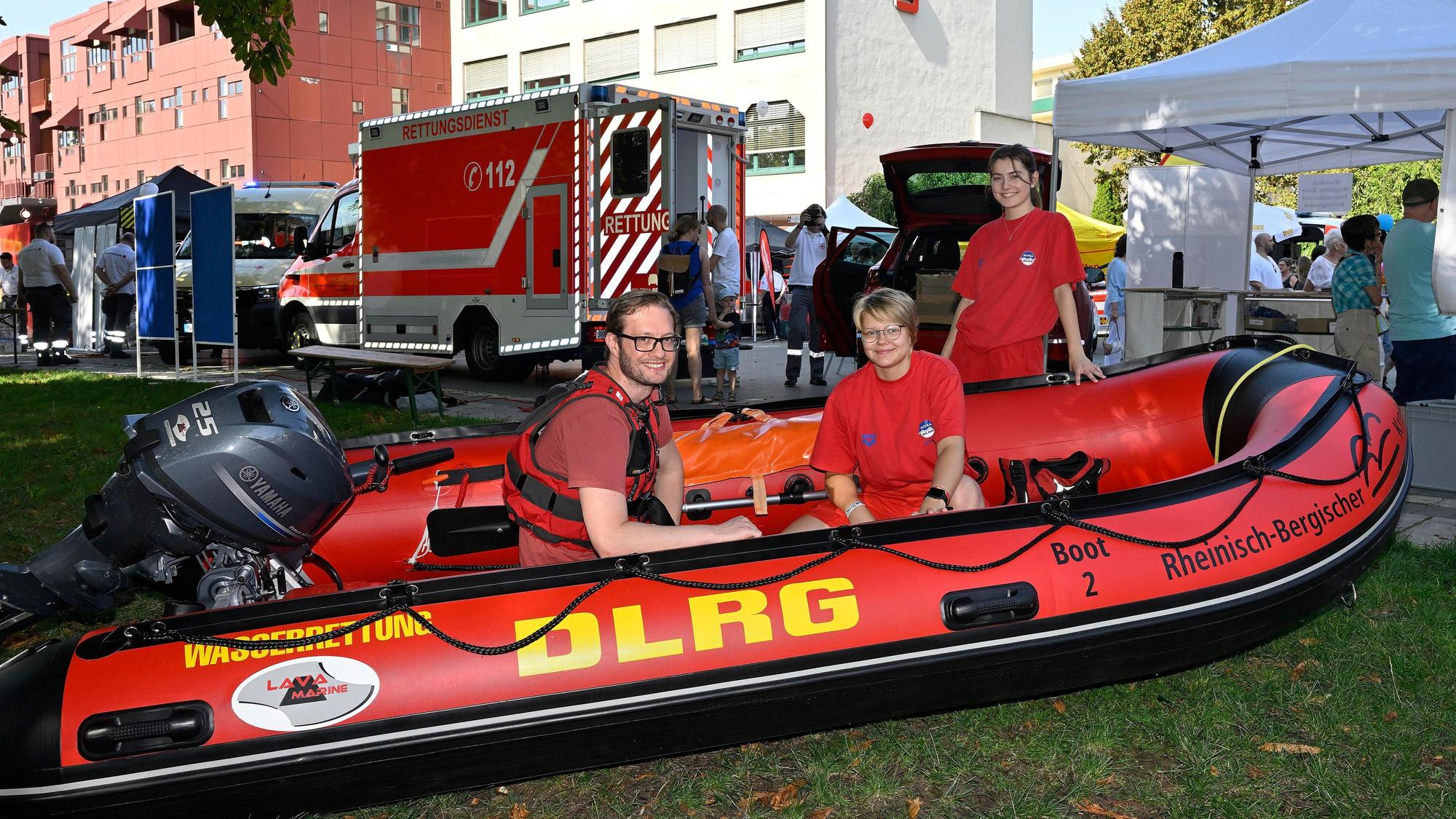 Zwei DLRGler sitzen in einem Rettungsboot im Bergisch Gladbacher Forum-Park.