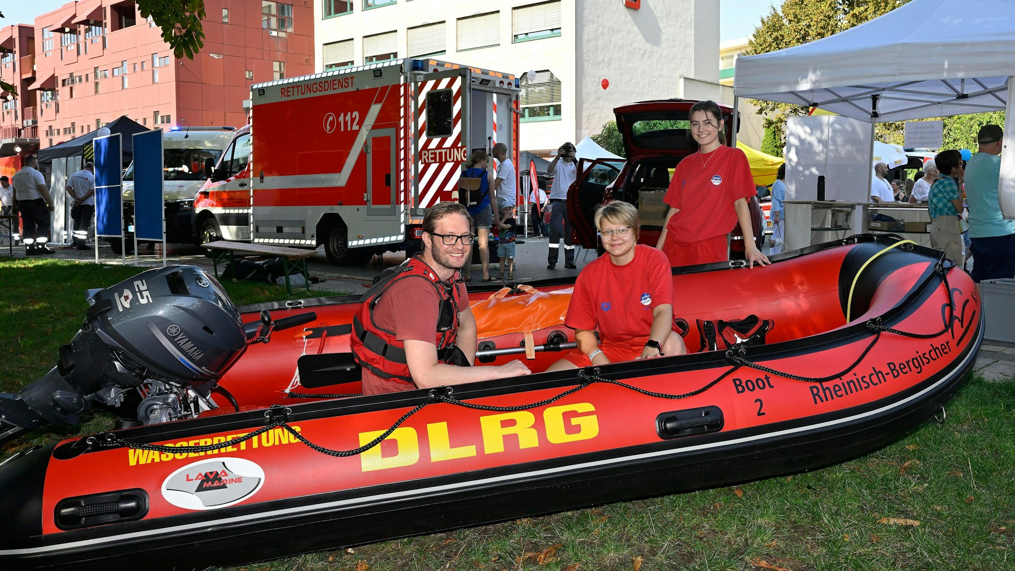 Zwei DLRGler sitzen in einem Rettungsboot im Bergisch Gladbacher Forum-Park.