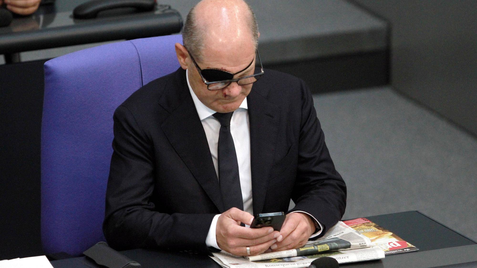 Bundeskanzler Olaf Scholz mit Handy im Bundestag. Den polnischen PiS-Vorsitzenden Jaroslaw Kaczynski braucht der SPD-Politiker einem Wahlwerbespot der polnischen Partei zufolge gar nicht erst anzurufen. (Archivbild)