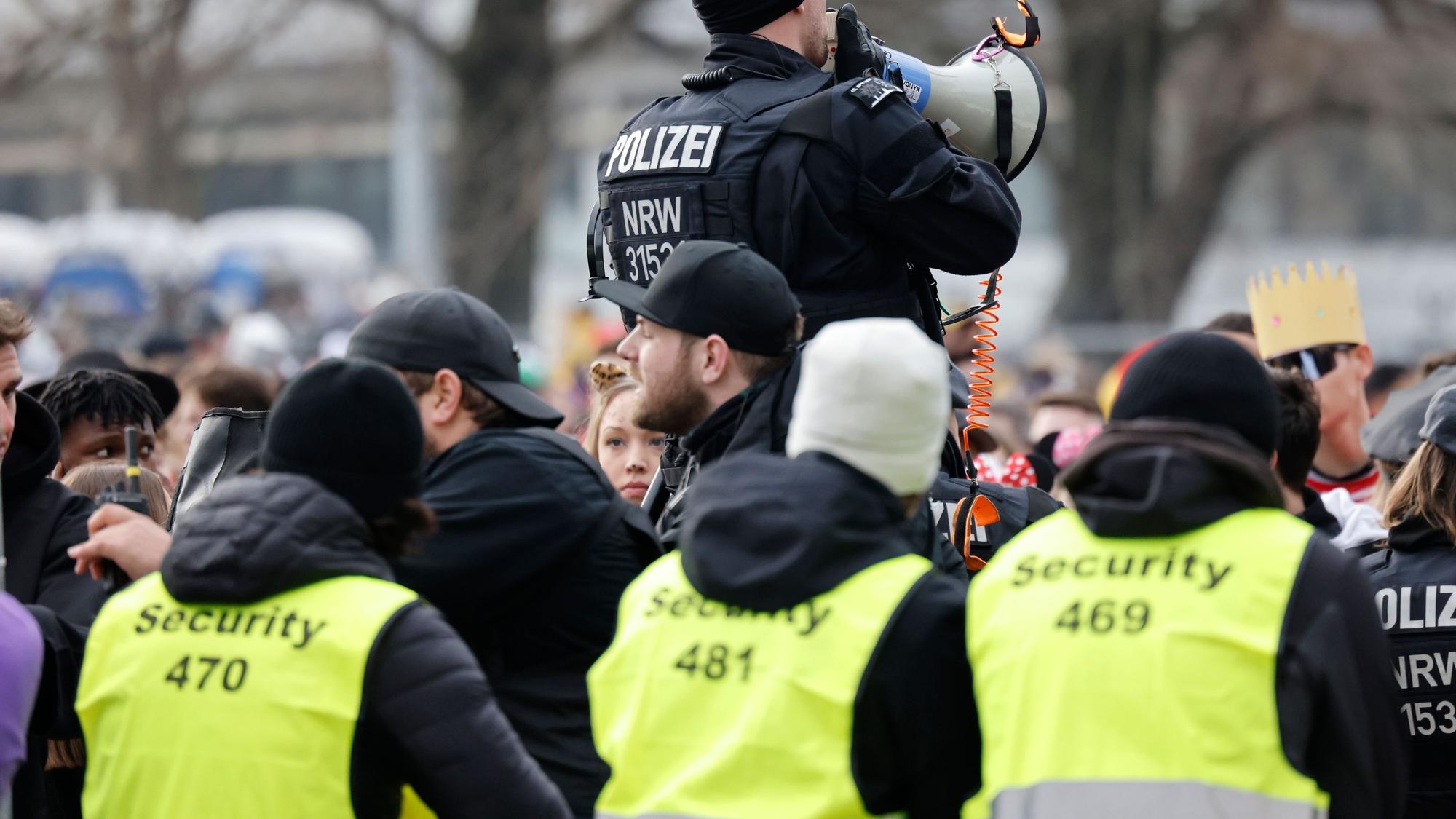 Drei Mitarbeiter von Sicherheitsfirmen und ein Polizist auf der Zülpicher Straße.