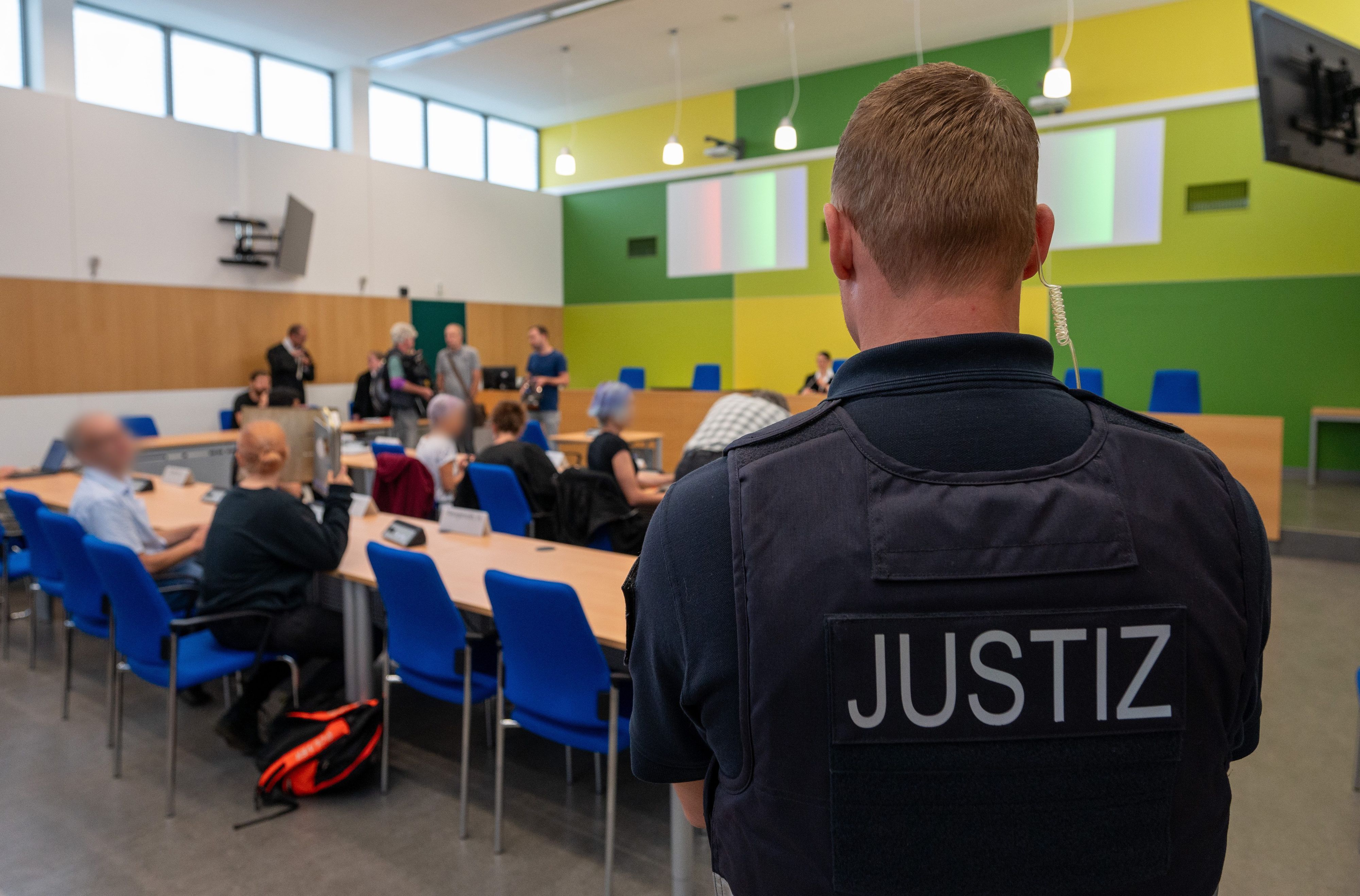 Angeklagte Klimaaktivisten sitzen mit ihren Anwälten in einem Gerichtssaal des Amtsgerichts Trier.