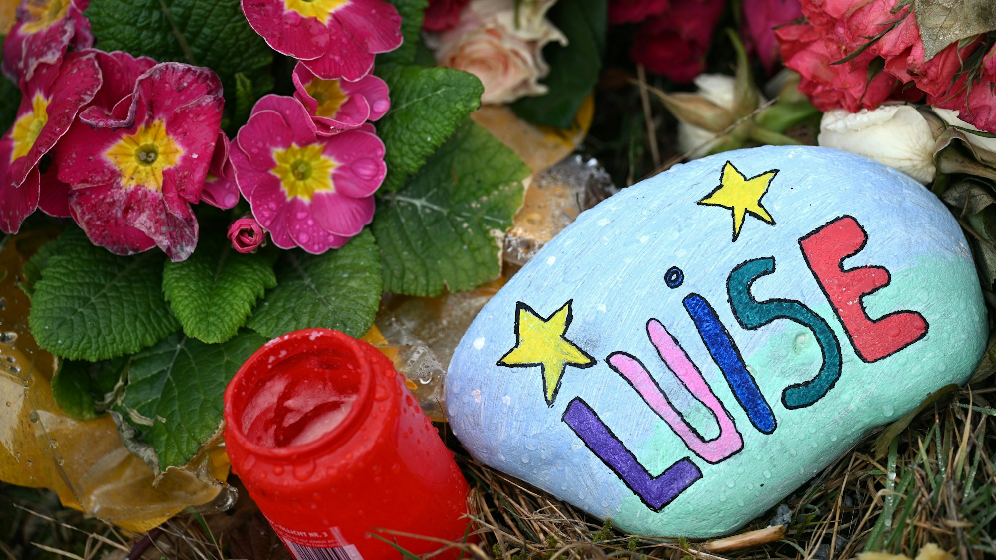 Blumen, Kerzen und ein bunt bemalter und mit „Luise“ beschriebener Stein liegen im März am Tatort in Freudenberg. Die Staatsanwaltschaft hat die Ermittlungen in dem Fall nun eingestellt. (Archivbild)