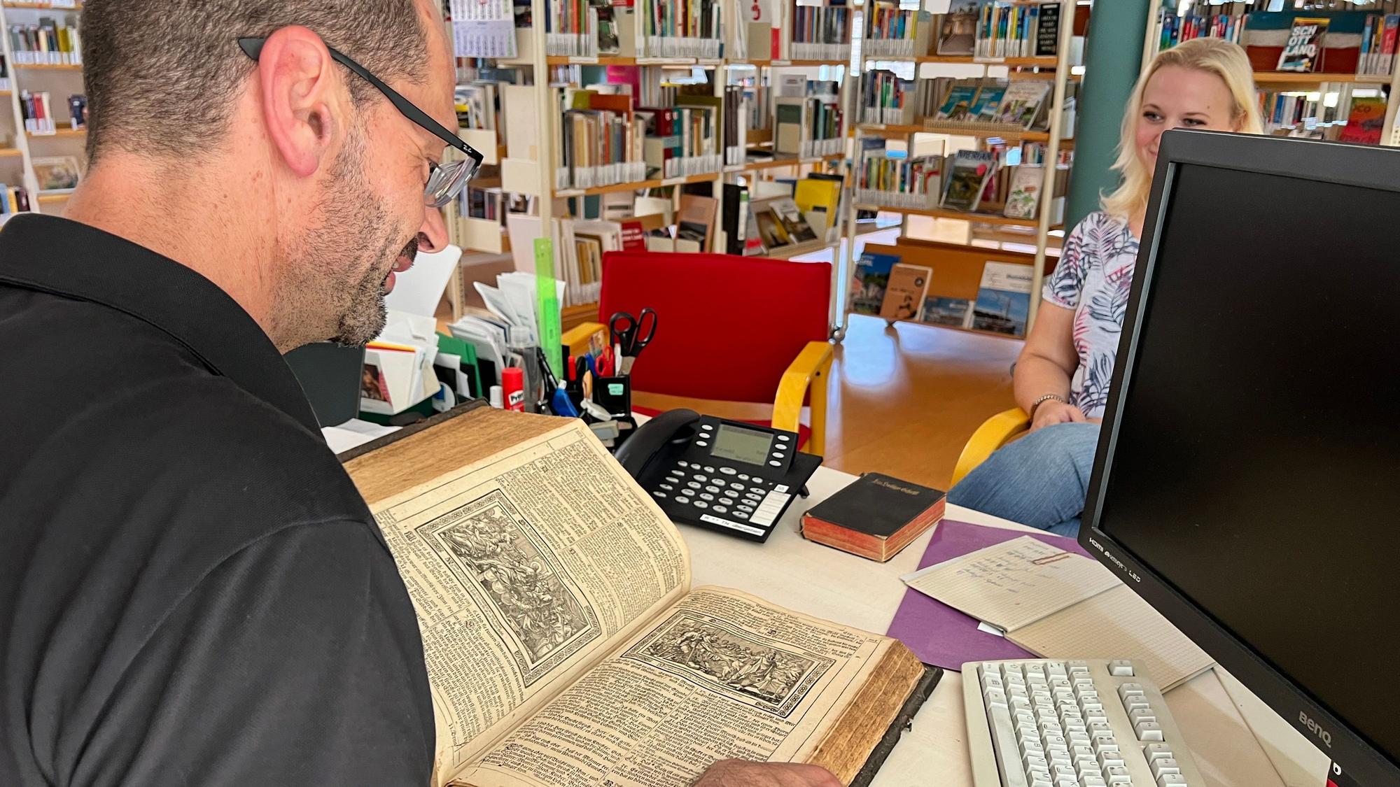 Bibliothekar Marcus Vaillant nimmt eine alte Bibel in Augenschein.