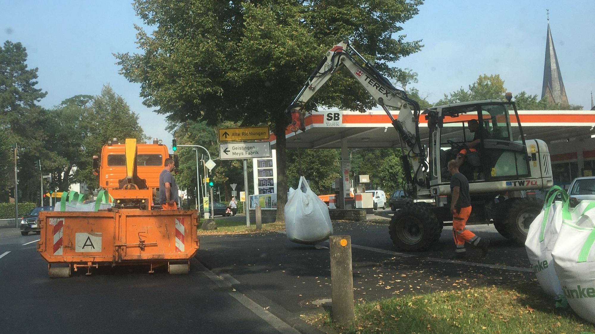 Mitarbeiter des Hennefer Bauhofs mit einem Lkw und einem Bagger bereiten auf der Frankfurter Straße den Bühnenaufbau für das Stadtfest vor.