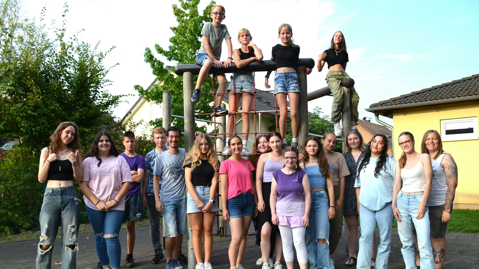 Jugendliche und Kinder vor und auf einem KIettergerüst.