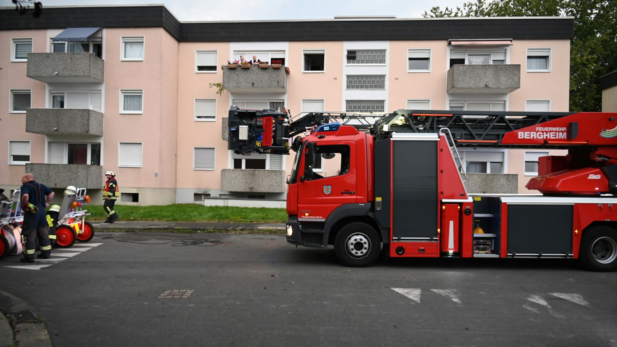Die Feuerwehr rettet zwei Personen mit einem Feuerwehrauto über eine Steckleiter vom Balkon.