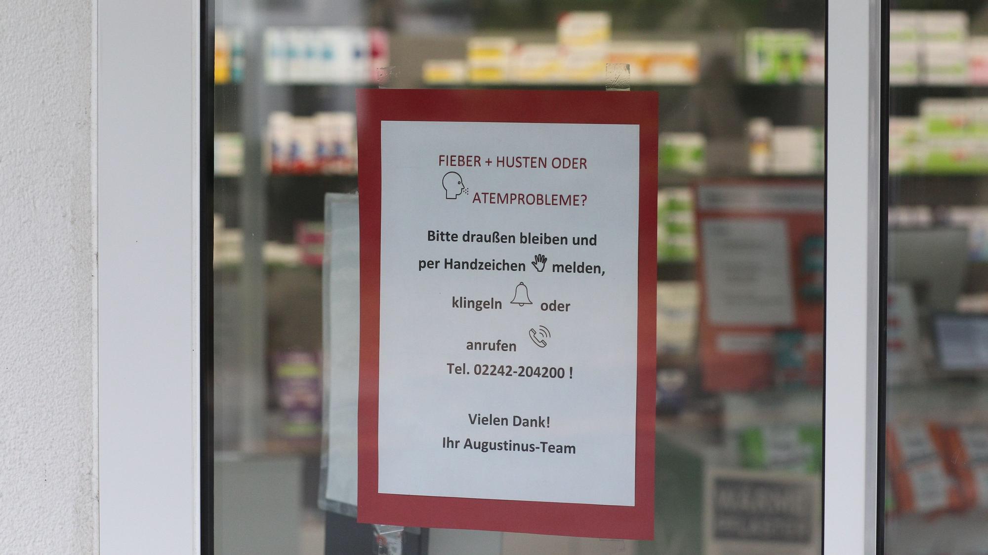 Ein Schild hängt an der Tür einer Apotheke.