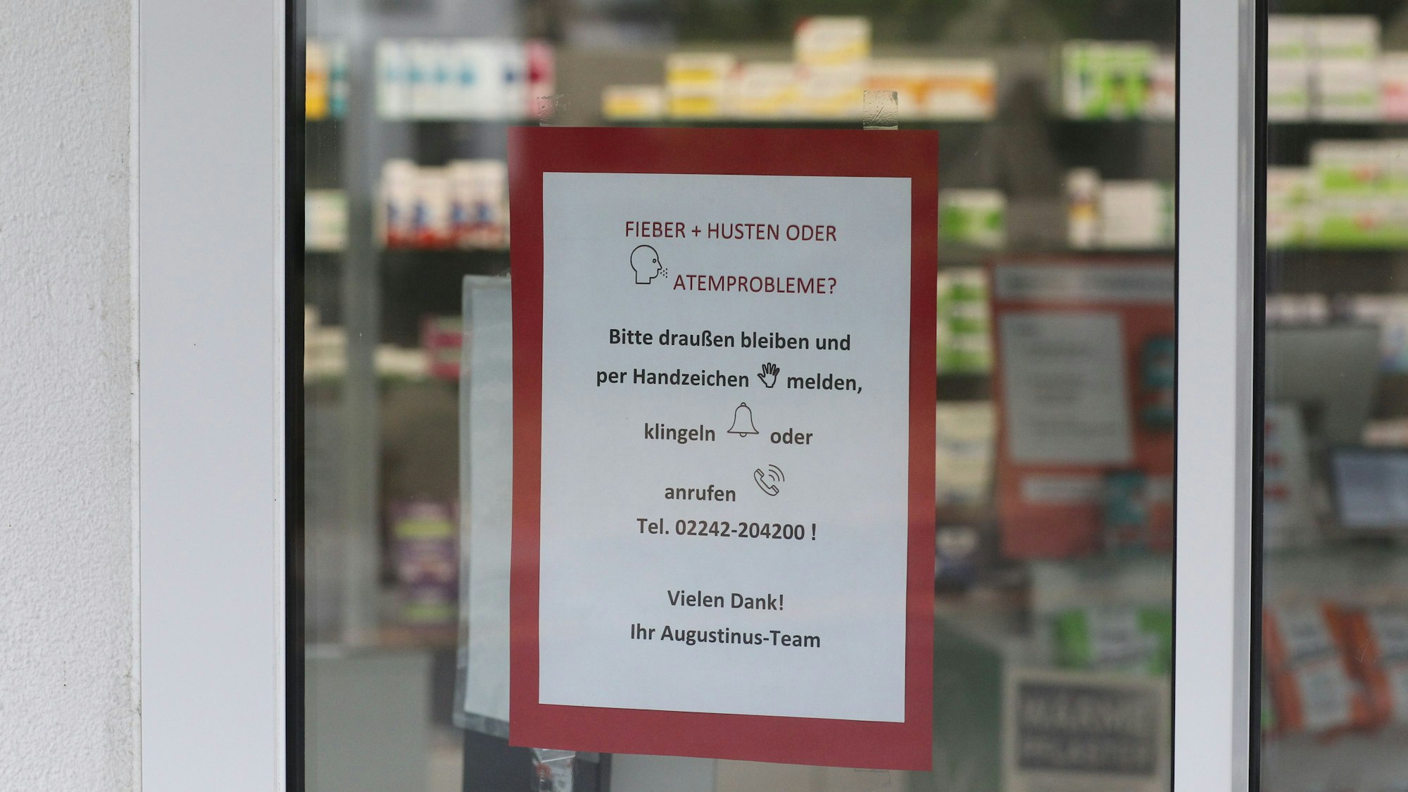 Ein Schild hängt an der Tür einer Apotheke.