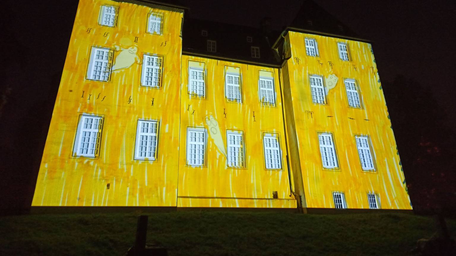 Das Alfterer Schloss ist gelb angestrahlt.