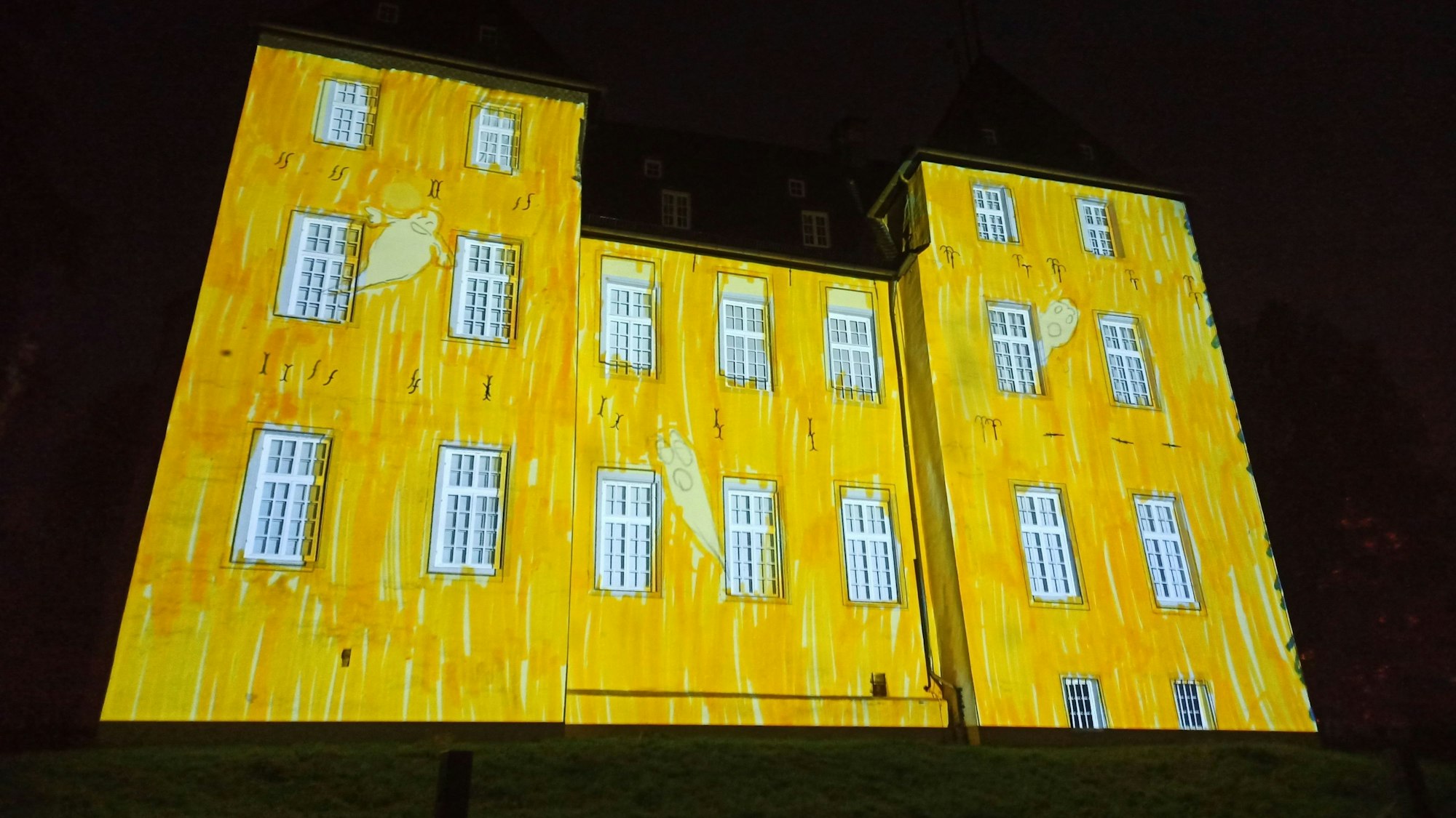 Das Alfterer Schloss ist gelb angestrahlt.