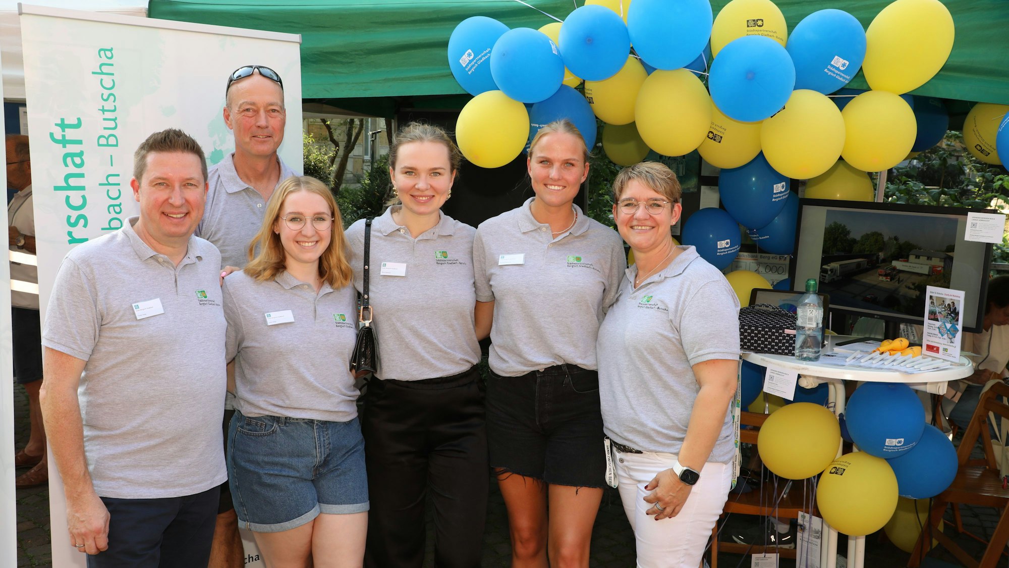 Sechs Menschen stehen am Stand des Vereins zur Förderung der Städtepartnerschaft Bergisch Gladbach – Butscha auf dem Bergisch Gladbacher Stadtfest.