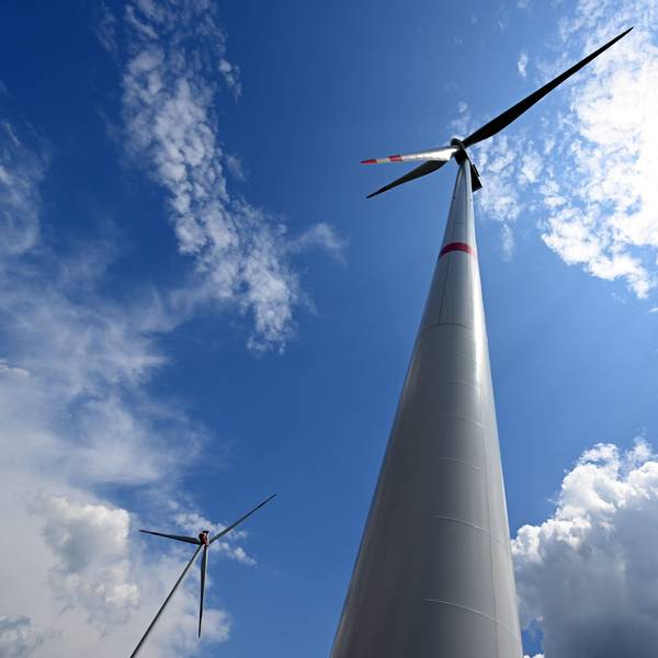 Wolken ziehen über Windräder zur Stromerzeugung.
