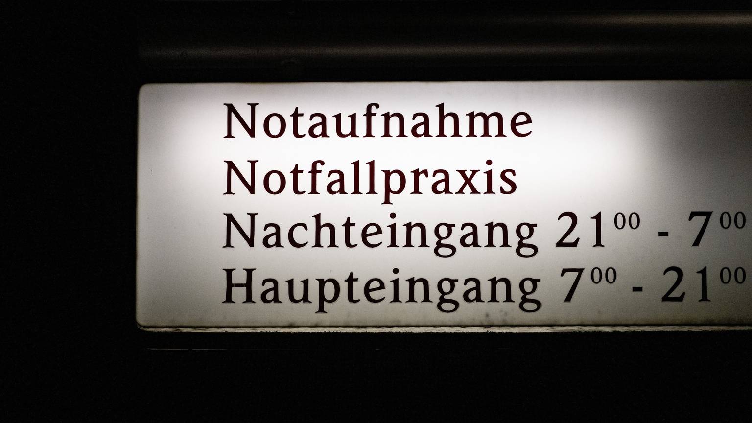 EIn Schild weist auf die Notaufnahme, die Notfallpraxis und Eingangszeiten eines Krankenhauses hin.