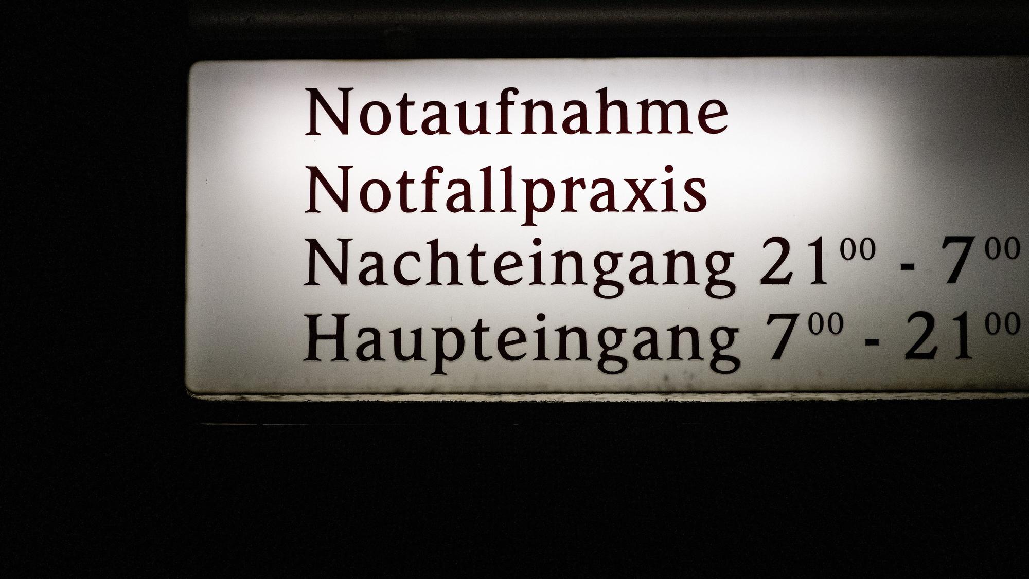 EIn Schild weist auf die Notaufnahme, die Notfallpraxis und Eingangszeiten eines Krankenhauses hin.