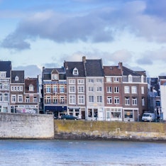 Die historische Altstadt von Maastricht an der Maas. Zu sehen sind mehrere markante und bunte Häuser an der Uferpromenade. (Symbolbild)