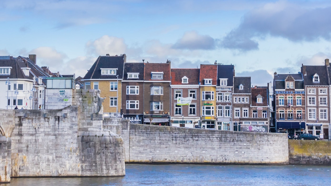 Die historische Altstadt von Maastricht an der Maas. Zu sehen sind mehrere markante und bunte Häuser an der Uferpromenade. (Symbolbild)