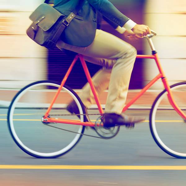 Mann fährt mit Arbeitstasche auf einem Fahrrad Foto: Getty Images/iStockphoto