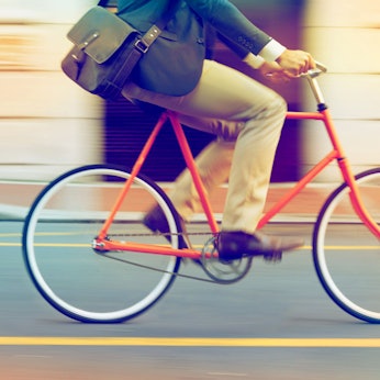 Mann fährt mit Arbeitstasche auf einem Fahrrad Foto: Getty Images/iStockphoto