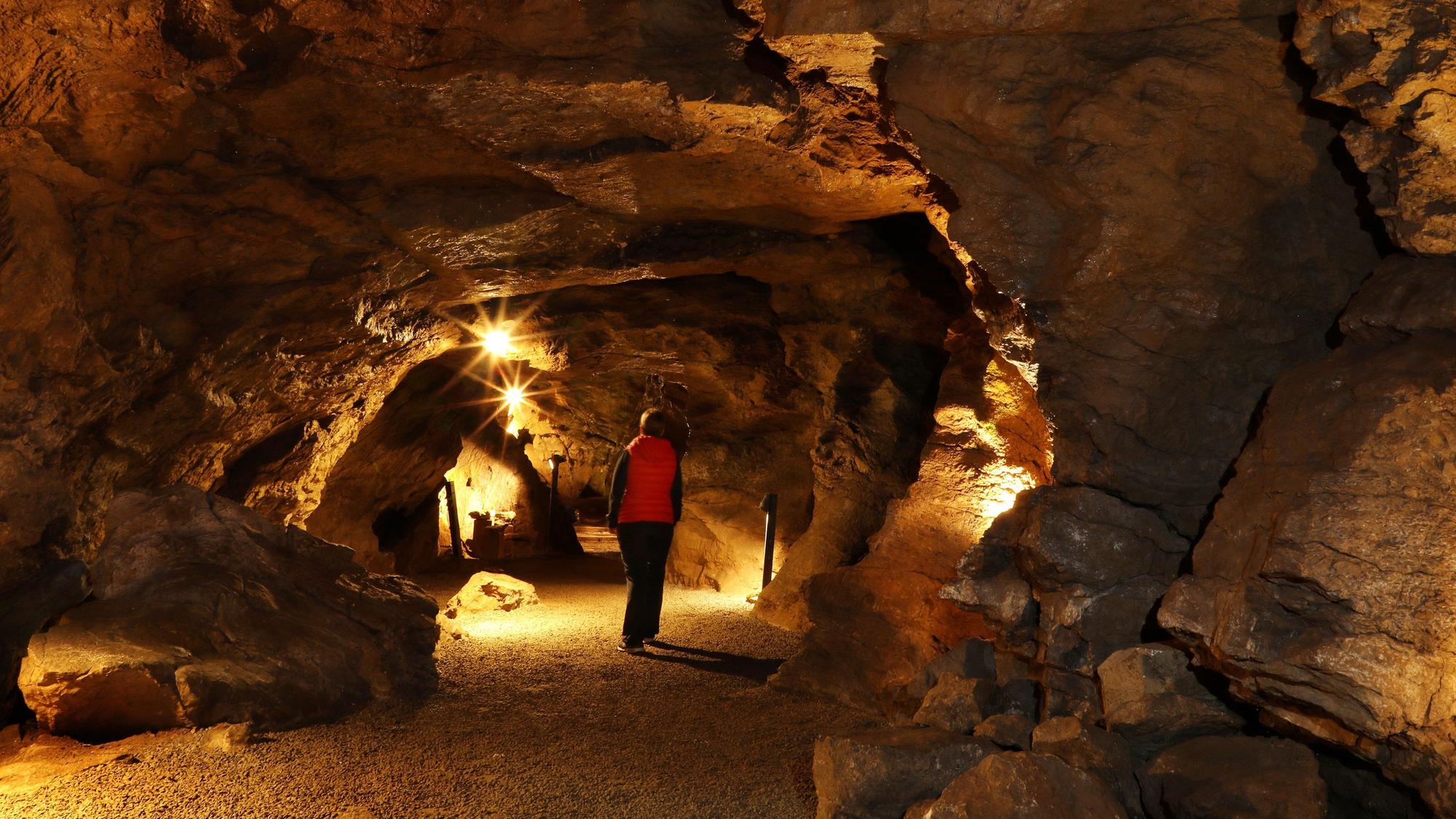 Besucherin in einer beleuchteten Höhle