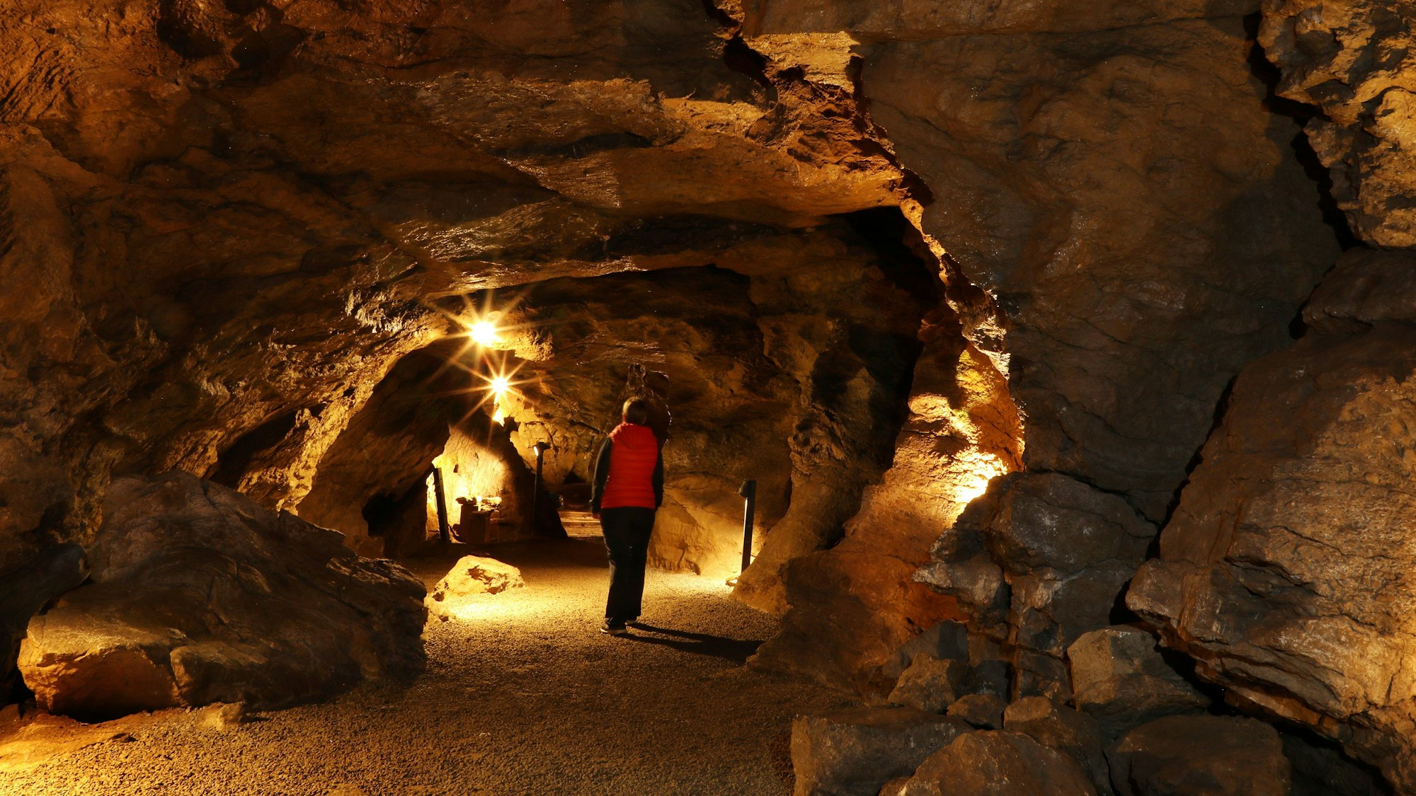 Besucherin in einer beleuchteten Höhle