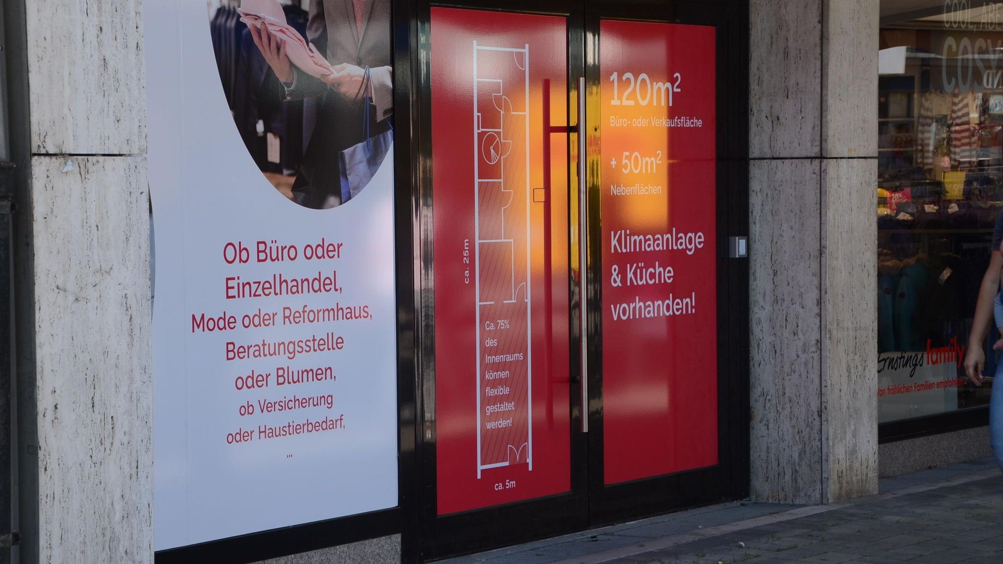 Ein geschlossenes Geschäft. Auf den zugeklebten Fensterscheiben und Türen wirbt ein Makler für die Vermietung.