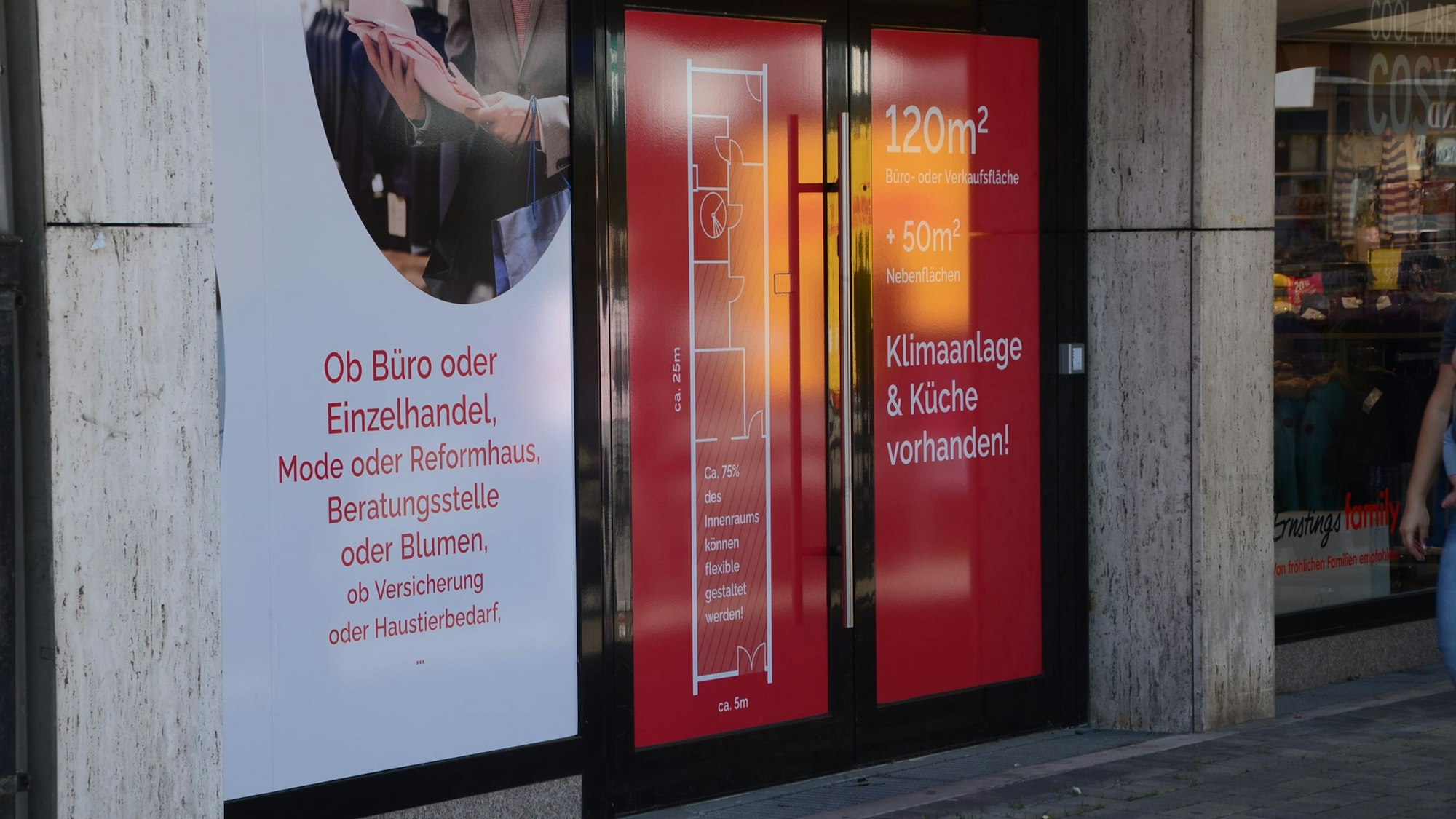 Ein geschlossenes Geschäft. Auf den zugeklebten Fensterscheiben und Türen wirbt ein Makler für die Vermietung.