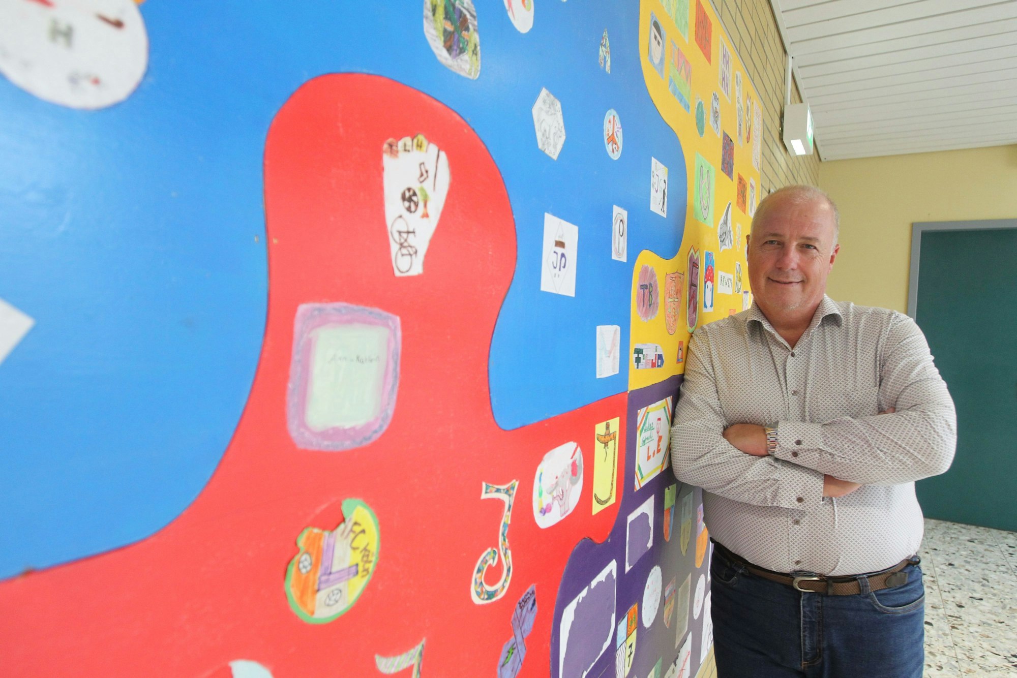 Schulleiter Alfred Himpeler mit dem Bild, das die erste Eingangsklasse 2013 gestaltet hat.