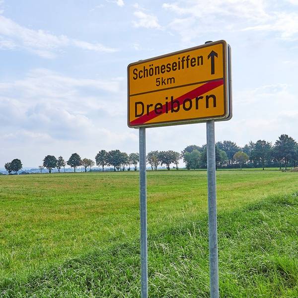Das Bild zeigt das Schild am Ortsausgang von Dreiborn mit dem Hinweis, dass es fünf Kilometer bis zum Nachbarort Schöneseiffen sind.