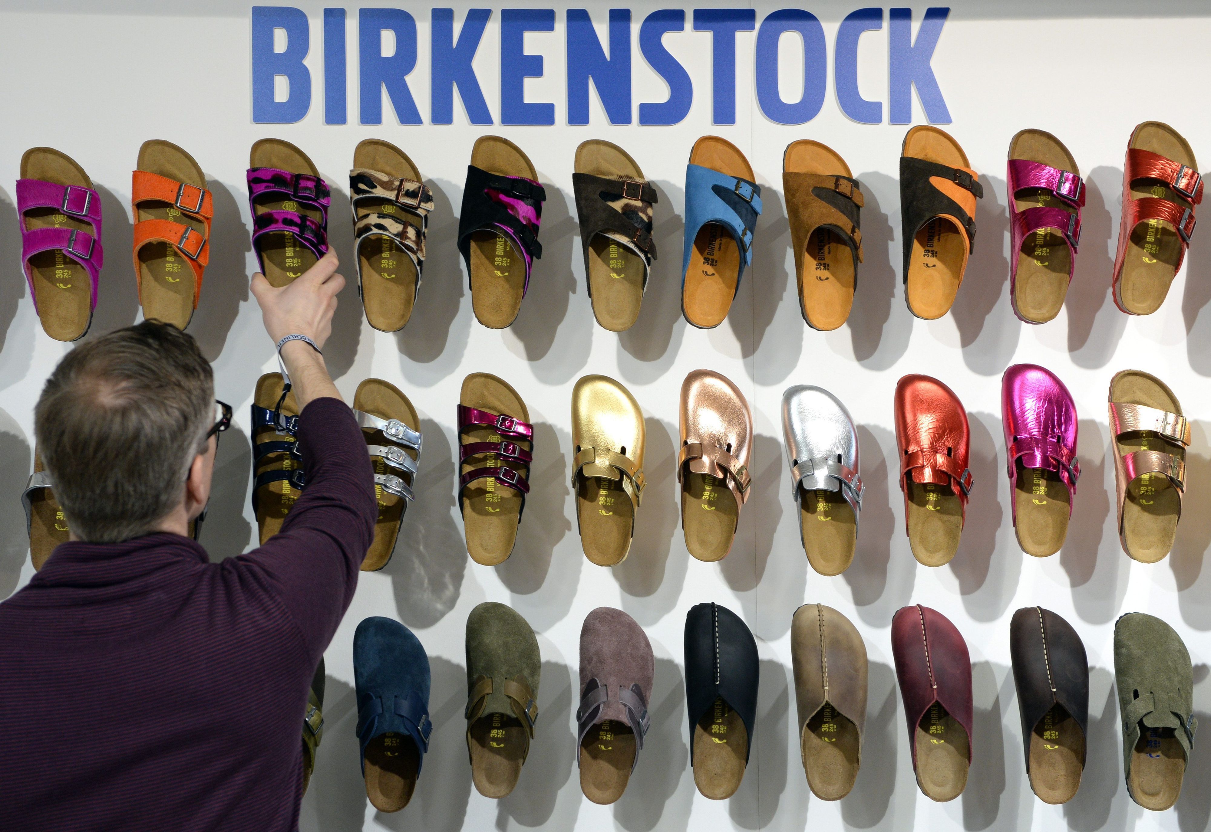 Ein Mitarbeiter sortiert auf der Modemesse "Bread & Butter" auf dem Gelände des früheren Flughafens Tempelhof in Berlin Schuhe des Herstellers Birkenstock. Der traditionsreiche Sandalen-Hersteller Birkenstock geht in den USA an die Börse.