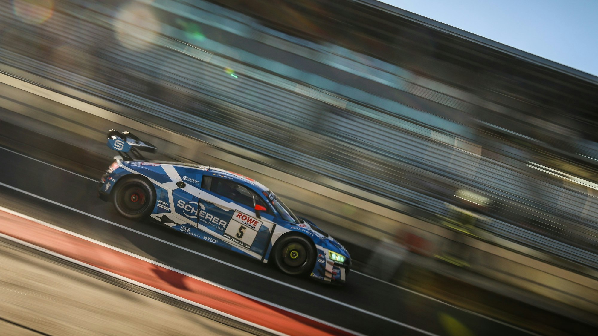 Der Audi von Frank Stippler rast über die Strecke, der Hintergrund ist verwischt.