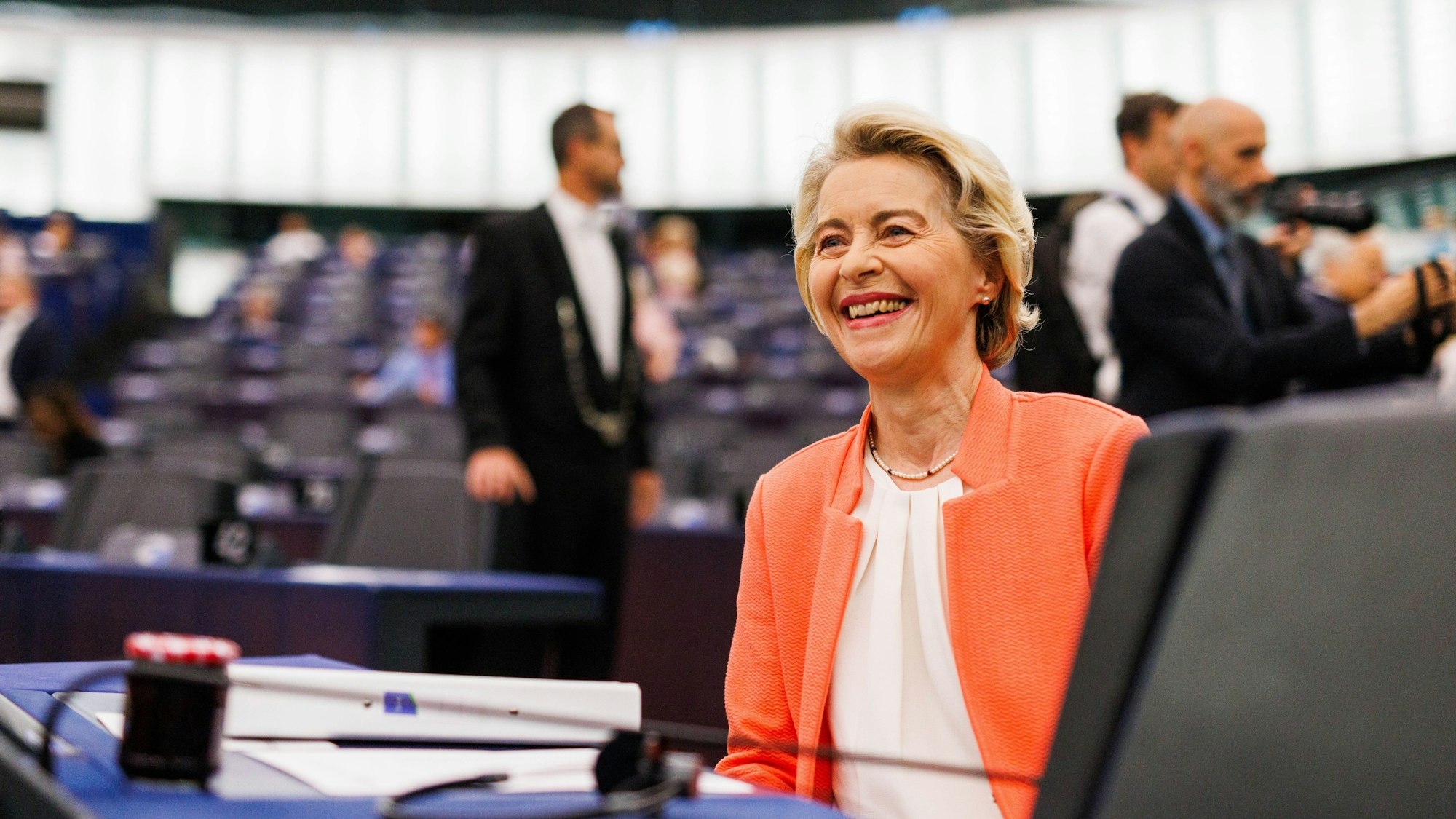 Ursula von der Leyen (CDU, Fraktion EVP), Präsidentin der Europäischen Kommission, sitzt im Gebäude des Europäischen Parlaments und lacht.