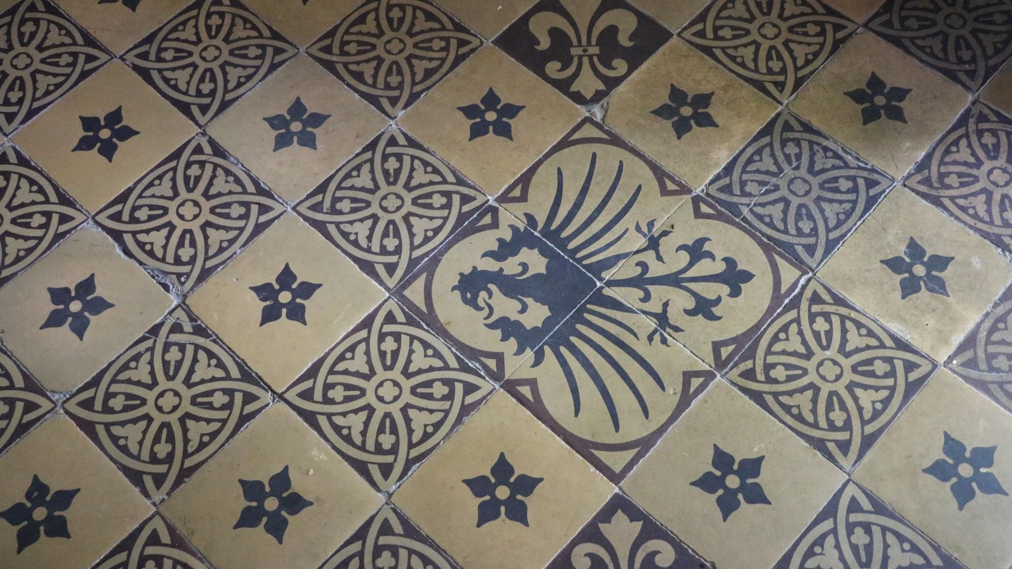 Blau-weiße Bodenfliesen mit einem Adlermotiv.