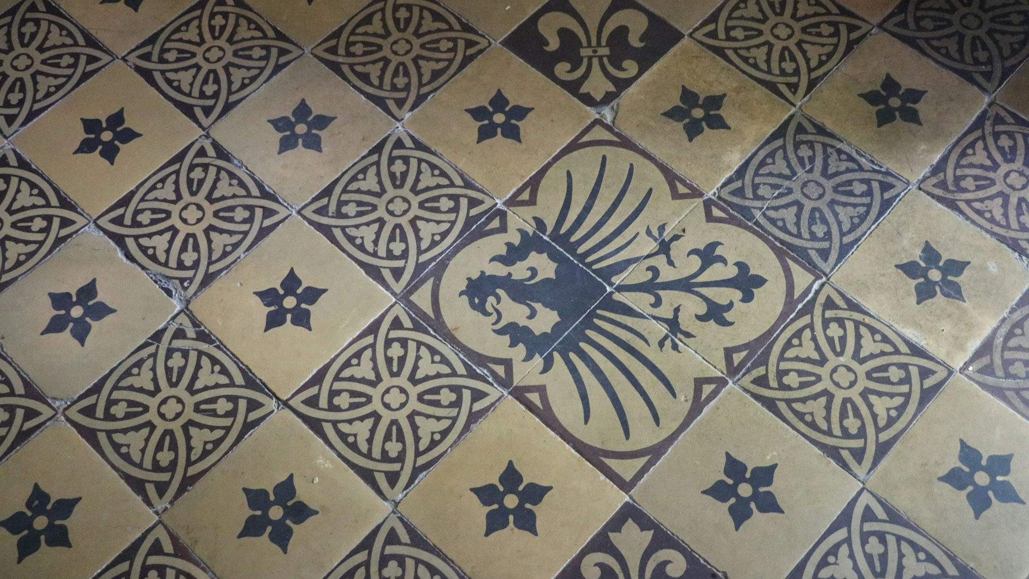 Blau-weiße Bodenfliesen mit einem Adlermotiv.