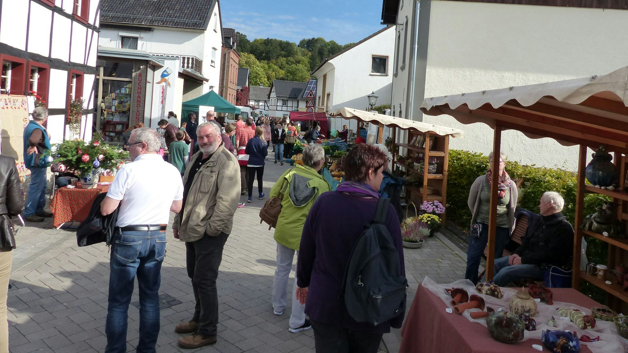 Menschen gehen entlang verschiedener Marktstände.