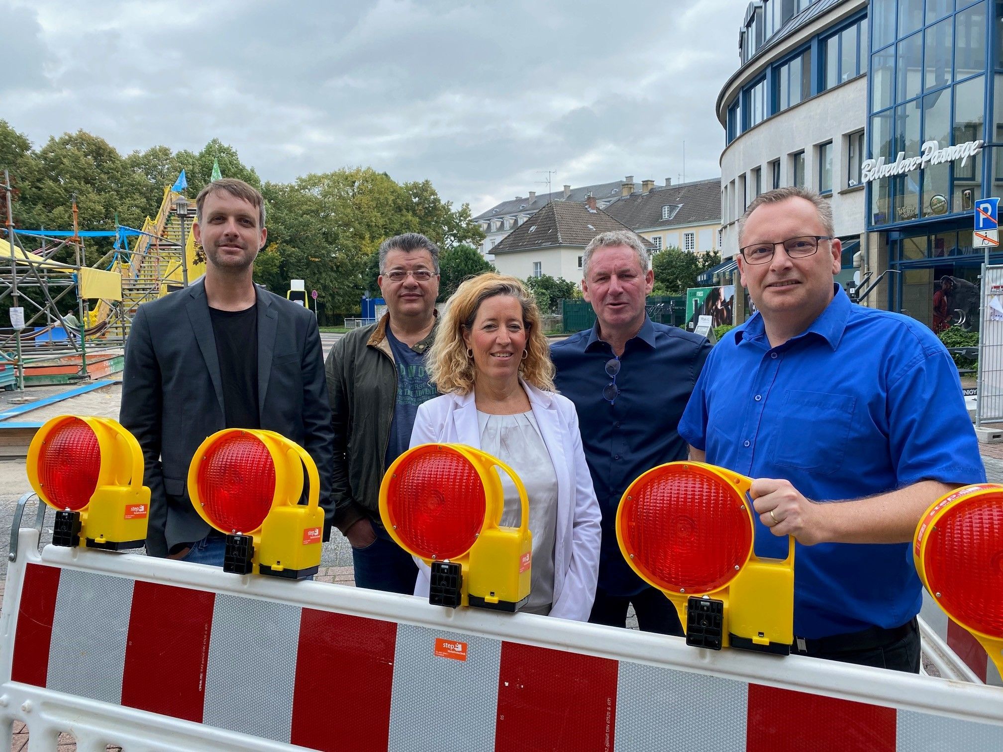 Das Foto zeigt Anwalt und Geschäftsleute hinter einer Absperrung auf dem Belvedere-Platz.