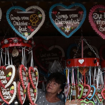 Eine Verkäuferin bereitet ihren Stand mit Lebkuchenherzen auf dem Oktoberfest vor.