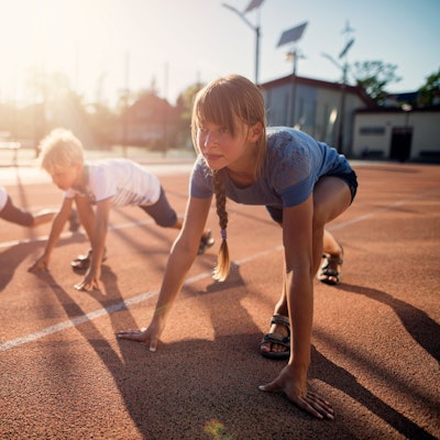 Drei Kinder kurz vor dem Startschuss eines Wettrennens.