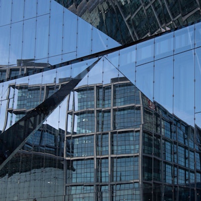 Teile des Berliner Hauptbahnhofes spiegeln sich in einer Fassade.
