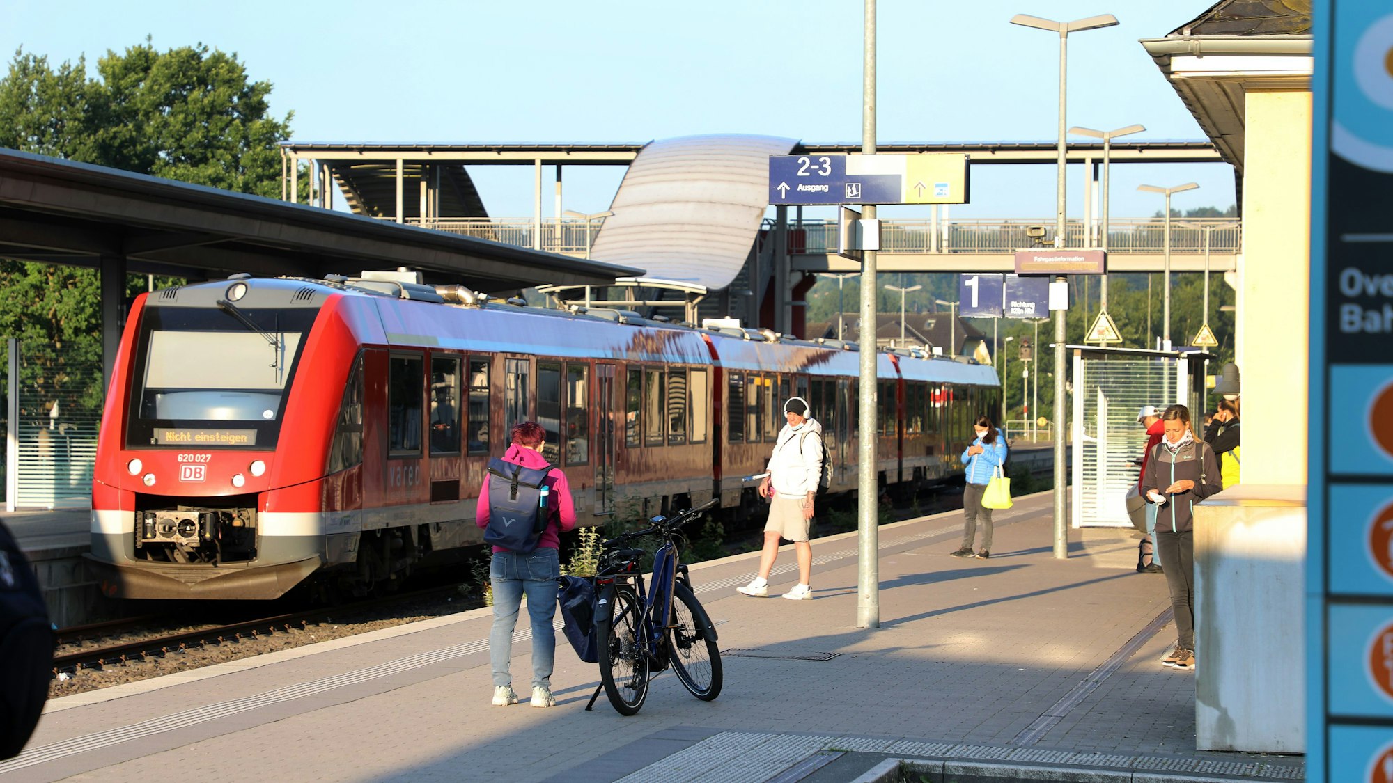 Ein Zug steht im Overather Bahnhof, Fahrgäste stehen auf dem Bahnsteig.