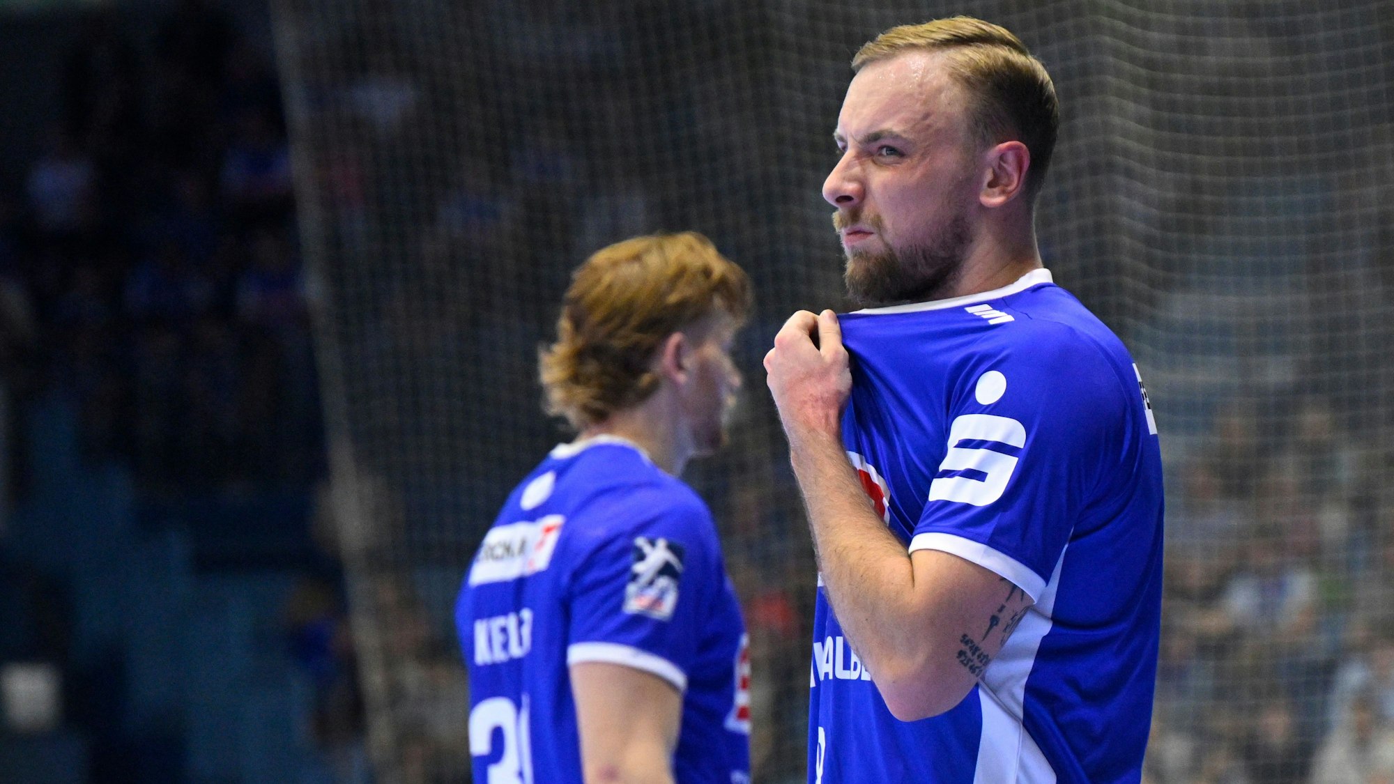 Lukas Blohme in seitlichem Porträt. Er zieht sich mit enttäuschtem Gesichtsausdruck an seinem Trikot.