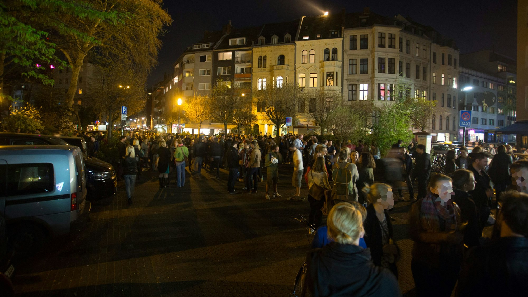 Menschen füllen den Brüsseler Platz bei Nacht.