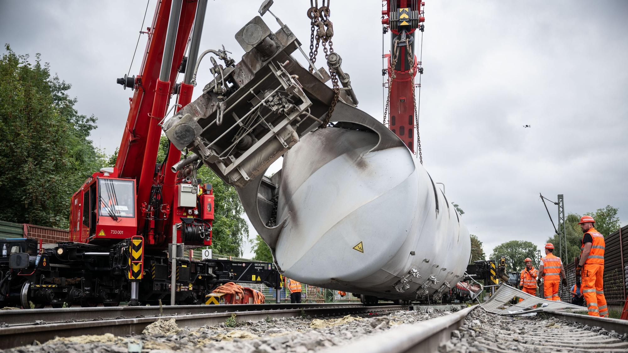 Arbeiter versuchen mit einem Kran den entgleisten Güterzug im nordrhein-westfälischen Geseke von den Gleisen zu bergen. Die Bahnstrecke zwischen Paderborn und Lippstadt bleibt für Wochen gesperrt.