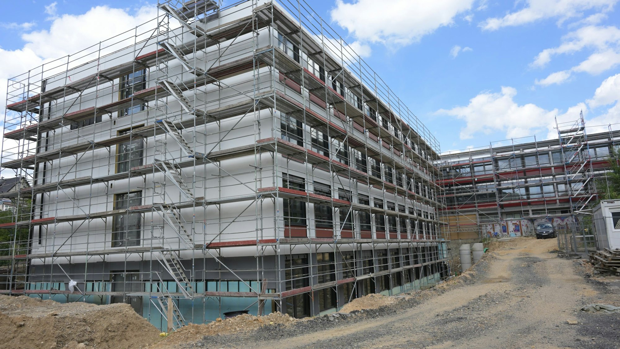 Zwei Gebäudetrakte des Nicolaus-Cusanus-Gymnasiums sind eingerüstet. Die Fensterscheiben sind schon eingesetzt.